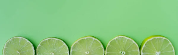 Top view of sliced lime on green background, banner — Fotografia de Stock