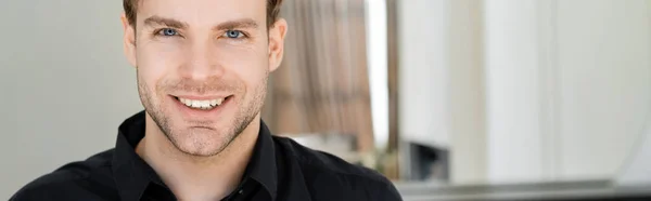 Portrait of young man smiling at camera at home, banner — Stock Photo