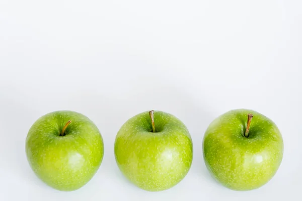 High angle view of green and ripe apples on white - foto de stock