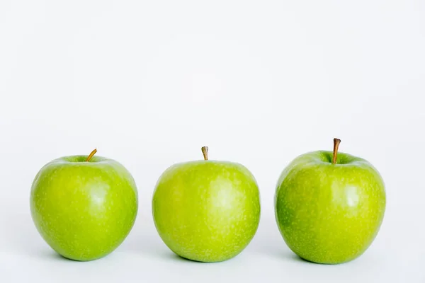 Row of green and ripe apples on white — Stock Photo