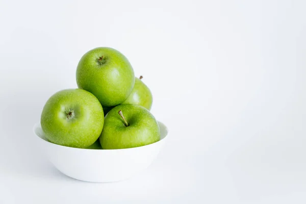 Bowl with green and ripe apples on white — стоковое фото
