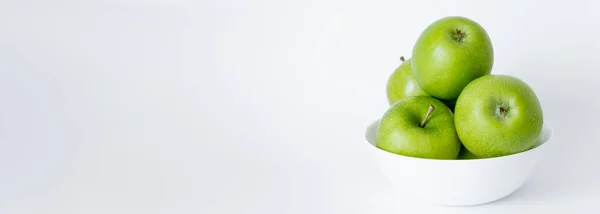 Bowl with green and ripe apples on white, banner — Stock Photo