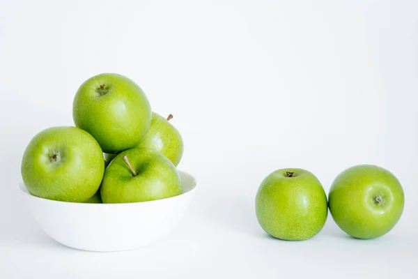 Bowl with green and fresh apples on white — Stock Photo