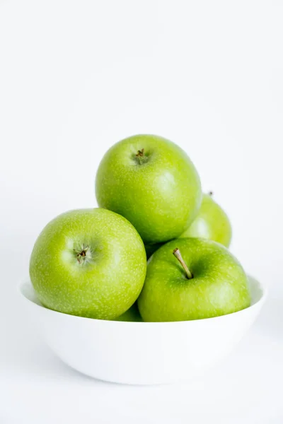 Bowl with green natural apples on white — стоковое фото
