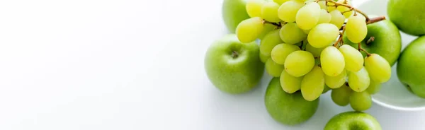 Top view of green and ripe apples near grapes on white, banner — Foto stock