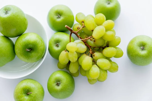 Top view of green and ripe apples in bowl near grapes on white — Photo de stock