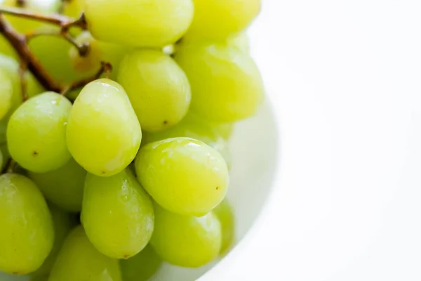 Close up view of fresh green grapes in bowl on white — Fotografia de Stock
