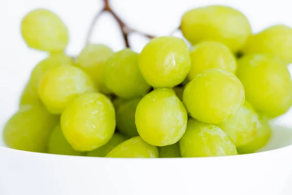 Vue rapprochée des raisins verts dans un bol sur fond blanc — Photo de stock