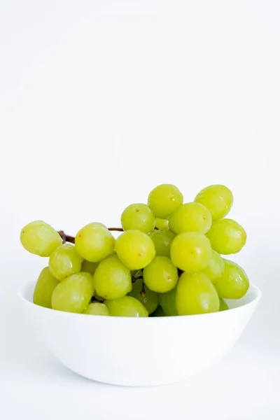 Sweet green grapes in bowl on white — Stock Photo