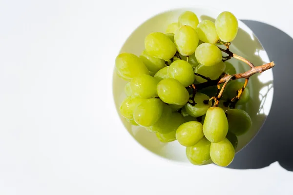 Top view of tasty green grapes in bowl on white — Photo de stock