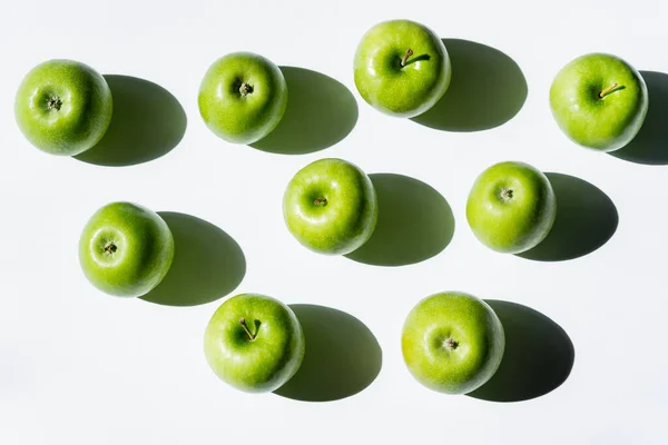 Top view of shadows near ripe apples on white — Stock Photo