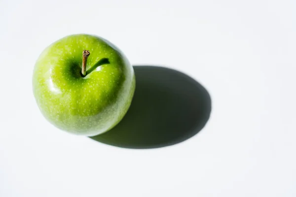 Top view of shadow near green apple on white — стоковое фото