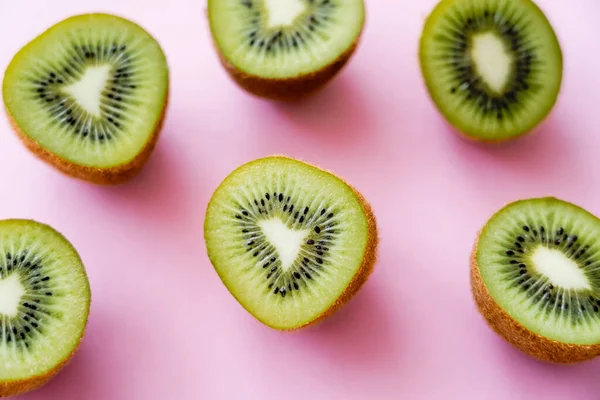 Organic and sweet kiwi halves on pink — Stockfoto