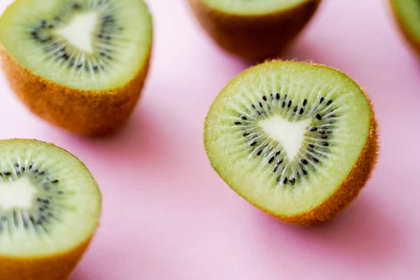 Close up view of sweet kiwi halves on pink — Fotografia de Stock