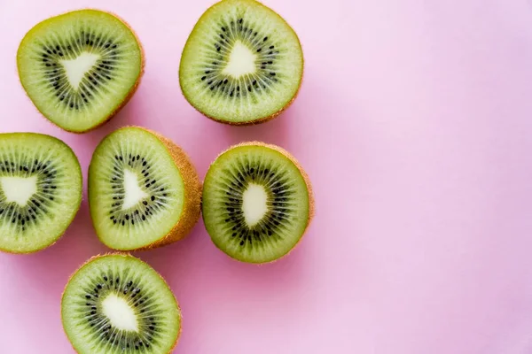 Top view of sweet kiwi halves on pink — Stock Photo