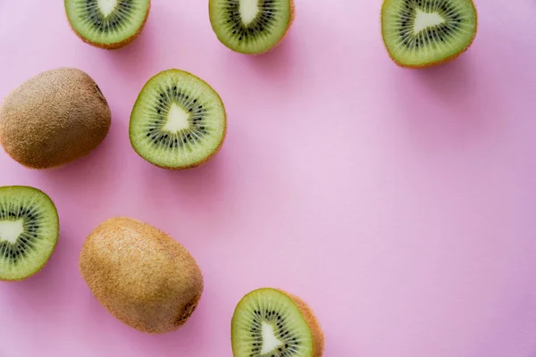 Vue de dessus des moitiés de kiwi bio sucrées sur rose — Photo de stock