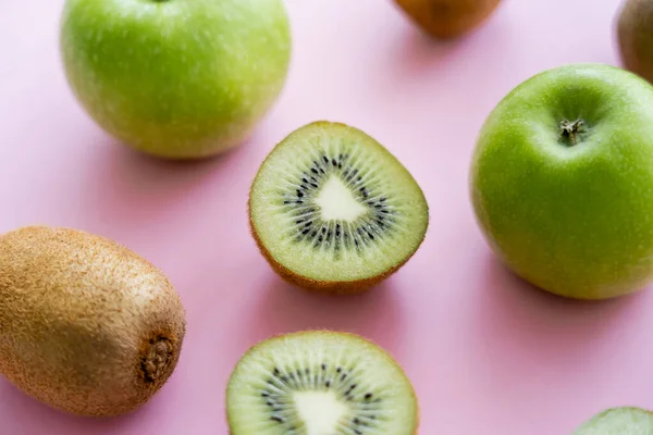Close up view of apples and sweet kiwi on pink — Stockfoto