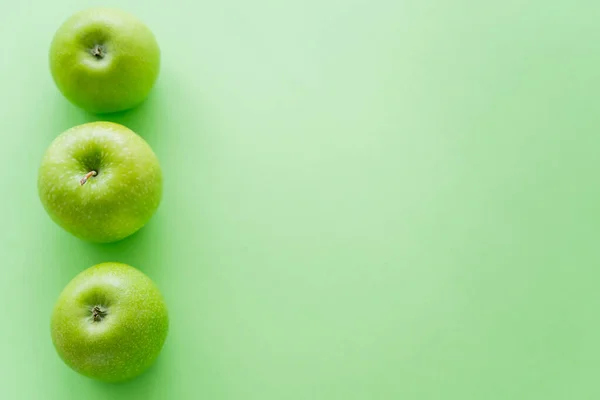 Vista superior da linha com maçãs frescas em verde — Fotografia de Stock