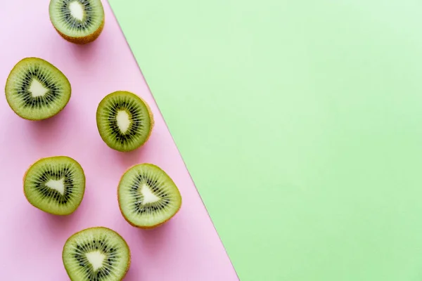 Top view of fresh kiwi fruit on green and pink — Stock Photo