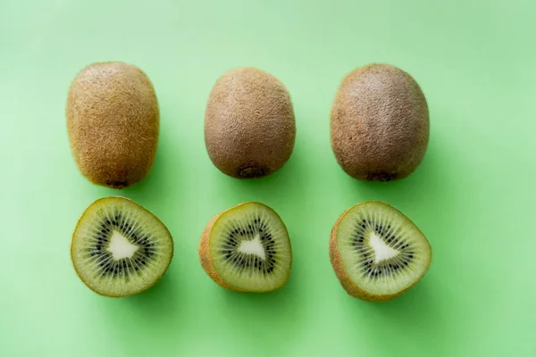 Flat lay of organic kiwi fruit on green — Photo de stock