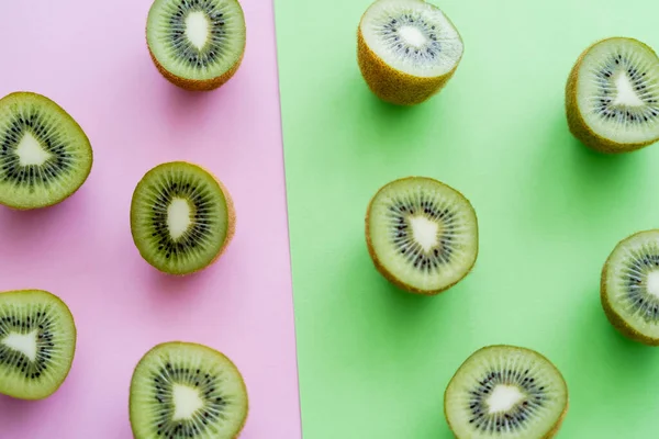 Flat lay of organic kiwi fruit on green and pink — Foto stock