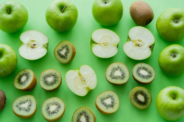 Плоская укладка спелых яблок и фруктов киви на зеленый — стоковое фото