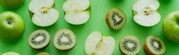 Colocação plana de maçãs e kiwi frutas metades em verde, banner — Fotografia de Stock