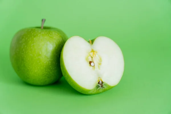 Manzanas jugosas y frescas sobre fondo verde - foto de stock