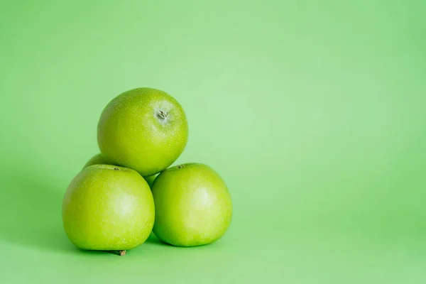 Manzanas enteras y frescas sobre fondo verde - foto de stock