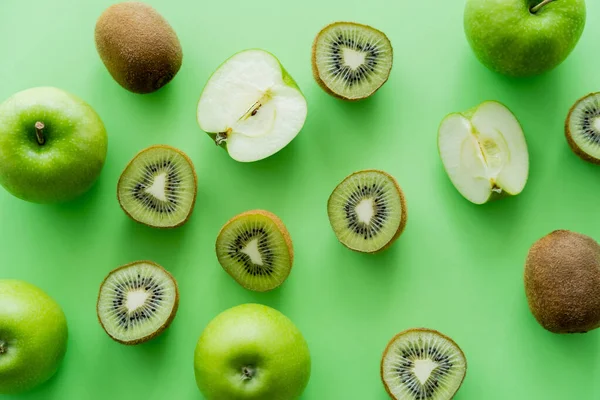 Вид зверху на смачні ківі та яблука на зеленому — стокове фото