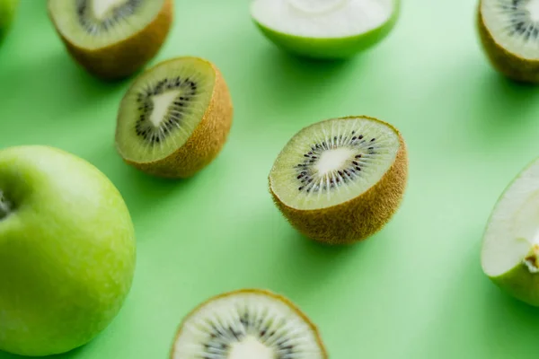 Close up view of tasty kiwi and apples on green — Photo de stock