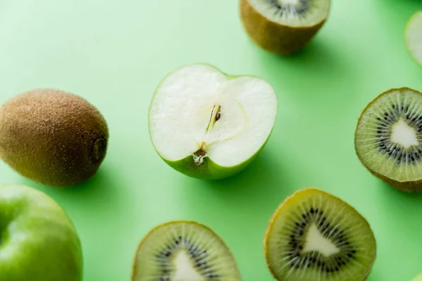 Vue de dessus de kiwi savoureux et pommes fraîches sur vert — Photo de stock