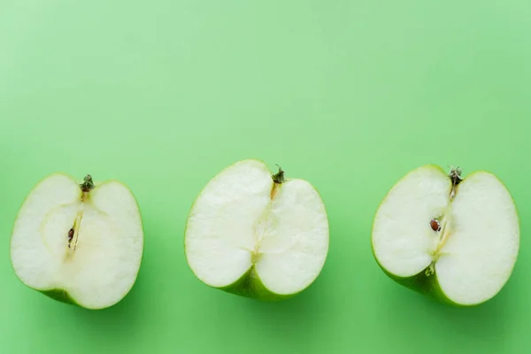 Plat couche de pommes coupées savoureuses sur vert — Photo de stock