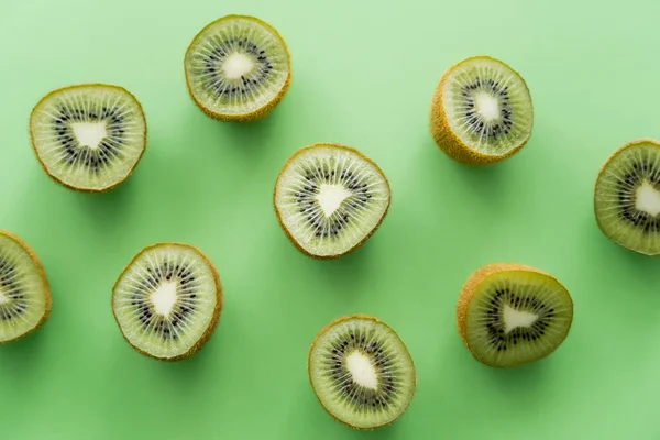 Couche plate de kiwi frais juteux sur vert — Photo de stock