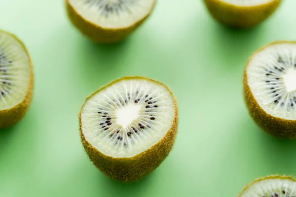 Nahaufnahme von saftigen frischen Kiwi-Früchten auf grünem Grund — Stockfoto