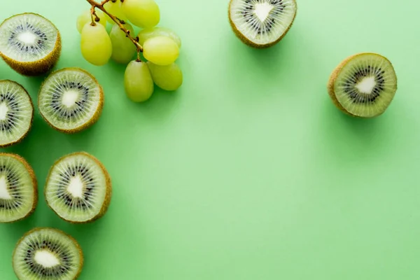 Vue de dessus des kiwis près des raisins sur vert — Photo de stock