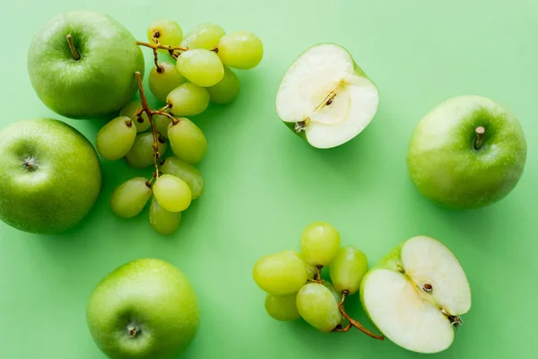 Vue de dessus des pommes et des raisins mûrs sur vert — Photo de stock