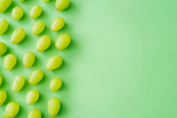 Flat lay of delicious grapes on green with copy space — Stock Photo