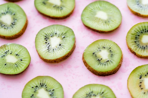 Close up view of sliced fresh kiwi on pink — Stockfoto