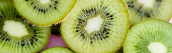 Top view of sliced green kiwi on pink, banner — Stockfoto