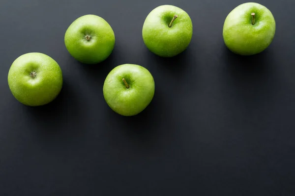 Top view of fresh and green apples on black — Photo de stock