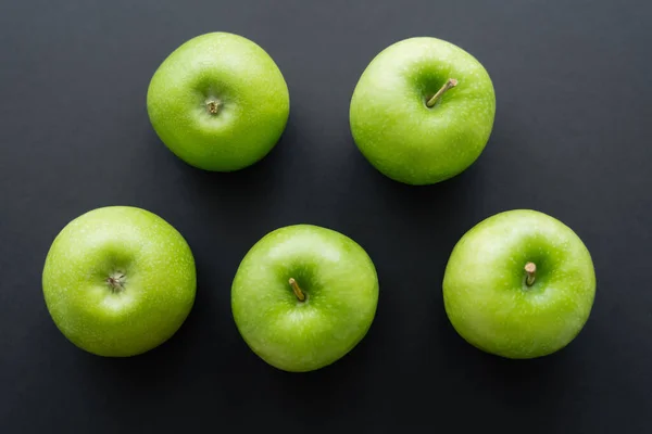 Tendido plano de manzanas frescas y verdes en negro - foto de stock