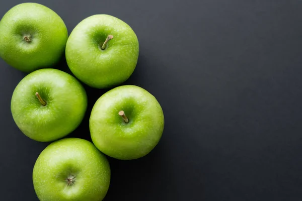 Top view of whole and green apples on black - foto de stock