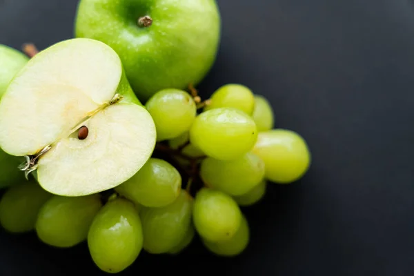 Top view of apple half on top on grapes on black — Fotografia de Stock