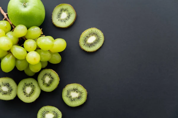 Вид зверху на зелені стиглі фрукти на чорному — стокове фото