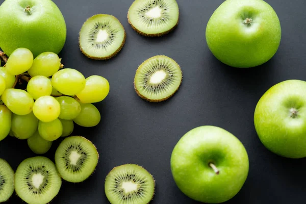 Вид зверху на зелені яблука біля стиглих фруктів на чорному — стокове фото