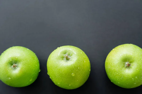 Ansicht von grünen und frischen Äpfeln mit Wassertropfen auf schwarz — Stockfoto