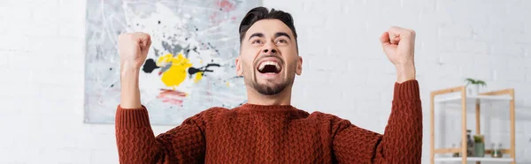 Overjoyed bookmaker showing triumph gesture and screaming at home, banner — Stock Photo