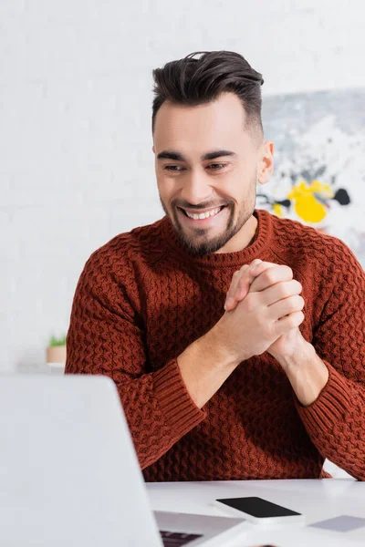 Cheerful bookmaker with clenched hands looking at laptop — Stock Photo