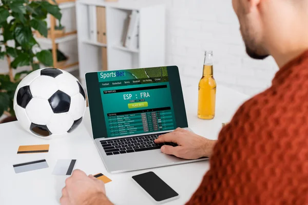 KYIV, UKRAINE - FEBRUARY 4, 2022: partial view of bookmaker using laptop with sportsbet website on screen — Stockfoto